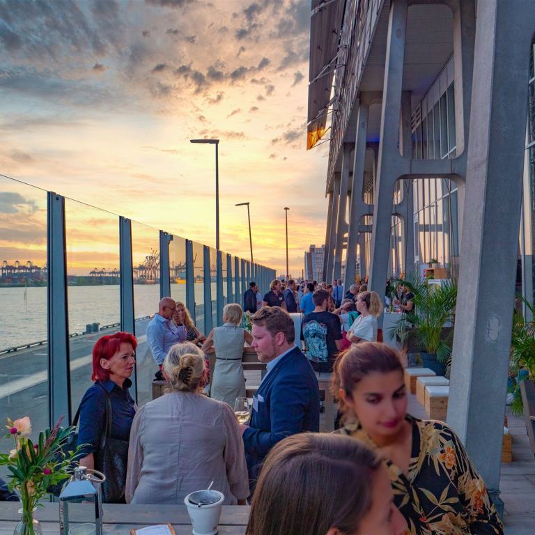 Gäste einer Veranstaltung auf der Elbterasse in ausgelassener, sommerlicher Atmosphäre.